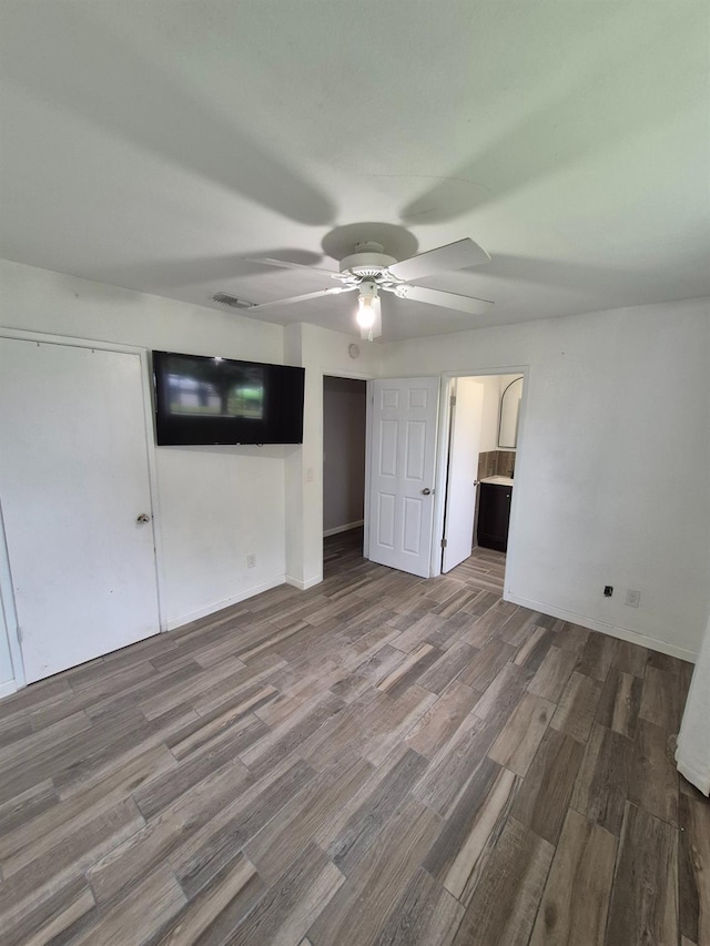 27261 Stanford Ave, Madera, CA 93637 - unfurnished bedroom with wood finished floors, a ceiling fan, and ensuite bath