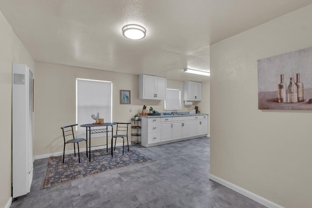 1417 Humboldt Ave, Chowchilla, CA 93610 - kitchen featuring a heating unit, white cabinets, and a textured ceiling