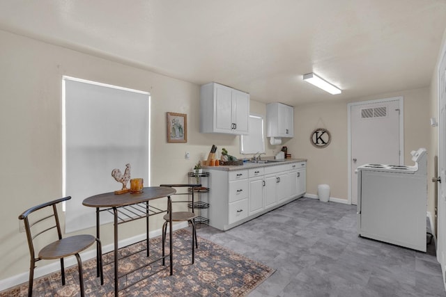 1417 Humboldt Ave, Chowchilla, CA 93610 - kitchen featuring washer / dryer, white cabinetry, light countertops, and light floors