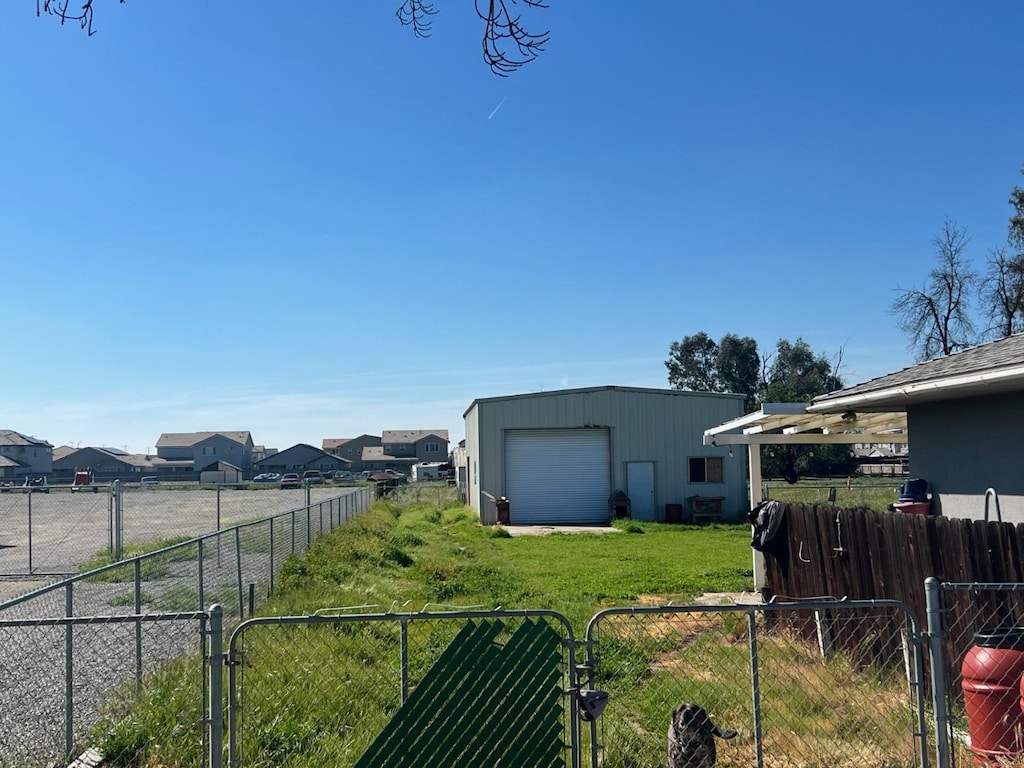 6073 E Clinton Ave, Fresno, CA 93727 - view of yard featuring fence, an outbuilding, a gate, and a garage