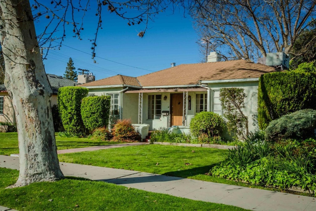 2423 N Thorne Ave, Fresno, CA 93704 - view of front facade with stucco siding, a chimney, and a front lawn