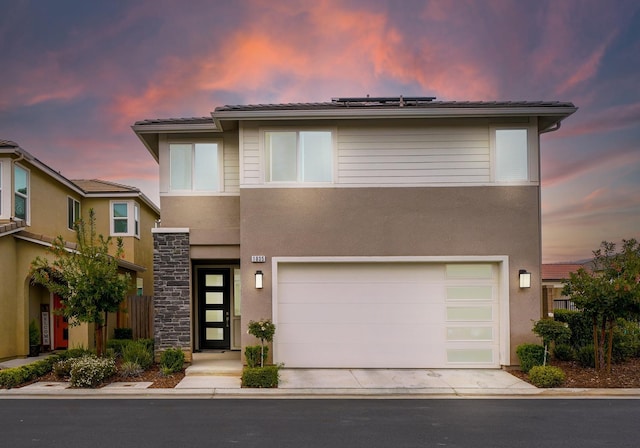 1935 Minarets Ln, Clovis, CA 93611 - view of front of home with stucco siding, roof mounted solar panels, concrete driveway, and an attached garage