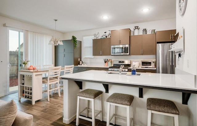1935 Minarets Ln, Clovis, CA 93611 - kitchen with a breakfast bar, light countertops, wood finished floors, and stainless steel appliances