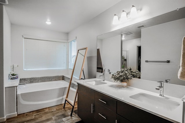 1935 Minarets Ln, Clovis, CA 93611 - full bathroom featuring double vanity, wood finished floors, a garden tub, and a sink