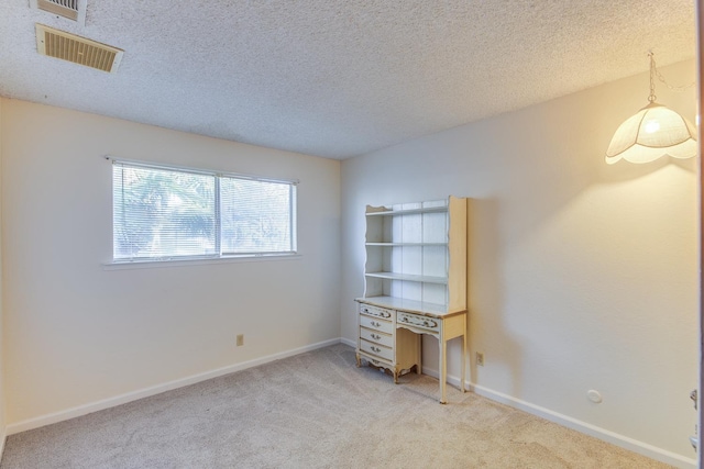 interior space featuring light carpet, visible vents, and a textured ceiling