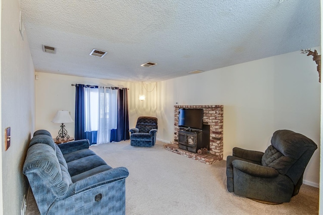 carpeted living area with a wood stove, visible vents, and a textured ceiling