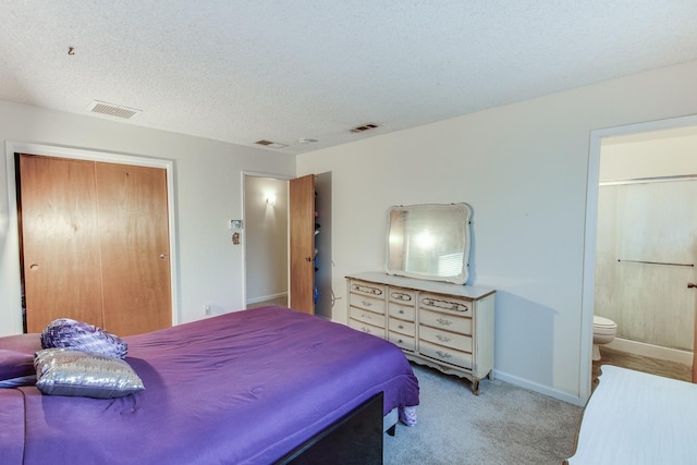 carpeted bedroom with baseboards, visible vents, a closet, and a textured ceiling