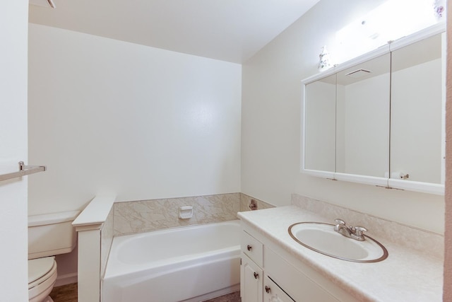 bathroom featuring toilet, vanity, and a garden tub