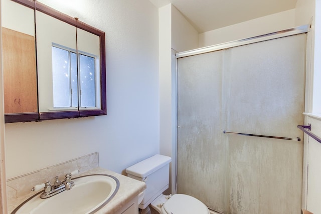 full bathroom featuring a shower with door, toilet, and vanity