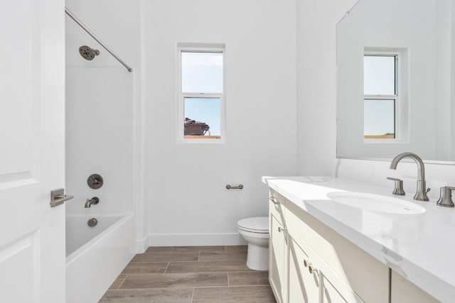 bathroom featuring a wealth of natural light, toilet, vanity, and wood finished floors