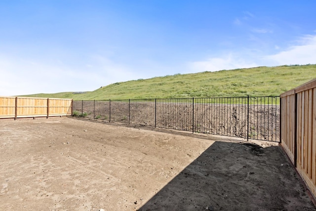 view of yard with fence and a rural view