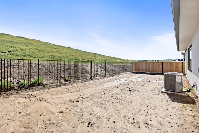 view of yard featuring central air condition unit and fence