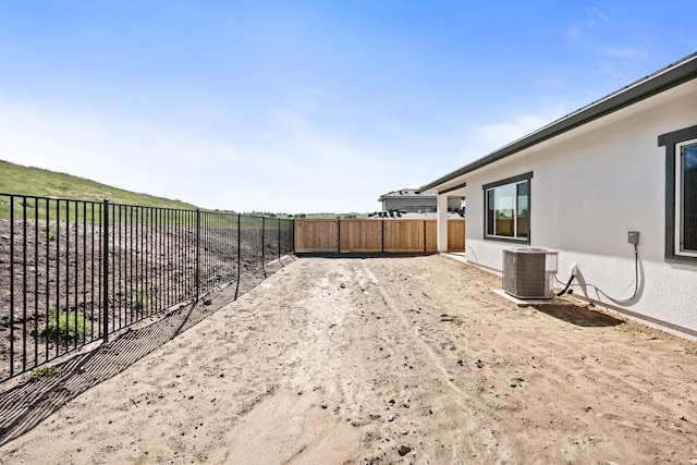 view of yard featuring a fenced backyard and central AC unit
