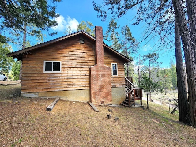 exterior space with crawl space, a chimney, and stairs