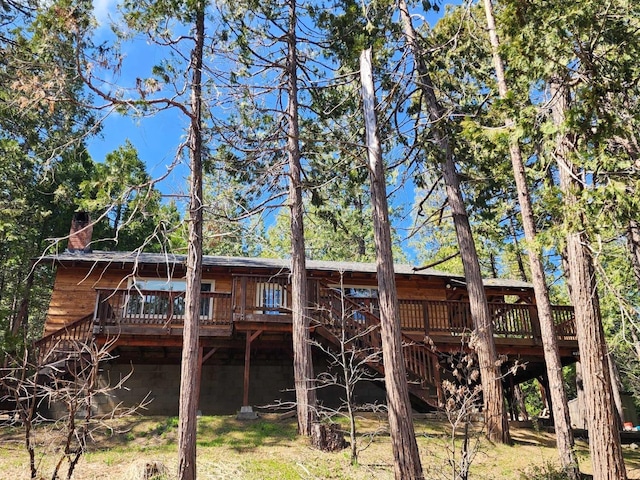 rear view of house with a chimney and a deck