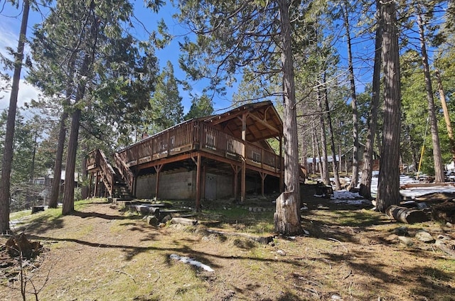 rear view of property with a garage, stairway, and a wooden deck
