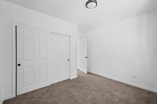 unfurnished bedroom with a closet, baseboards, and carpet floors