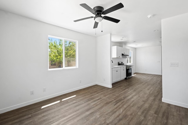 unfurnished living room with baseboards, dark wood finished floors, and a ceiling fan