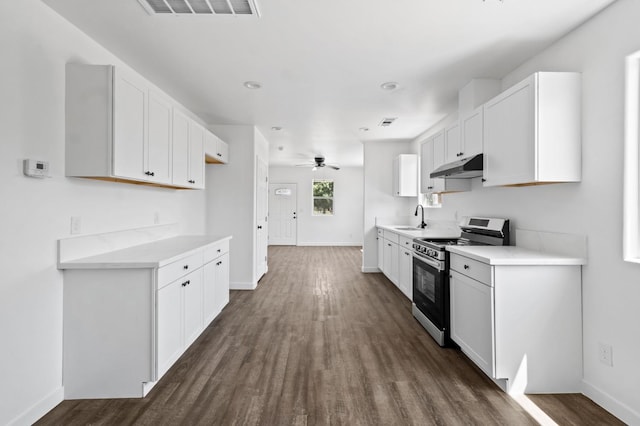 kitchen featuring electric range, visible vents, dark wood-type flooring, under cabinet range hood, and a sink