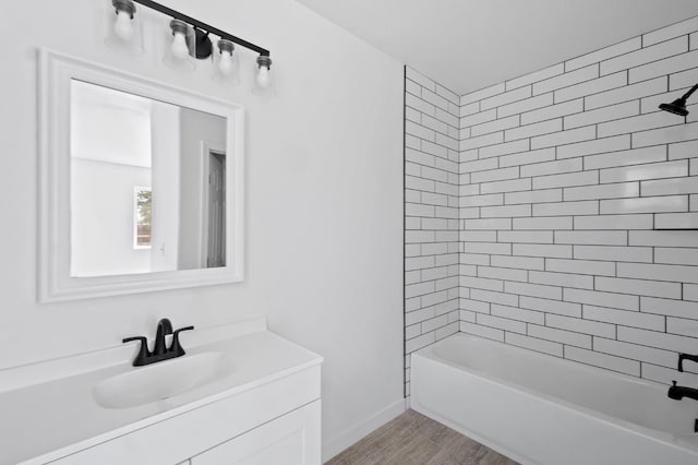 bathroom with baseboards, vanity,  shower combination, and wood finished floors