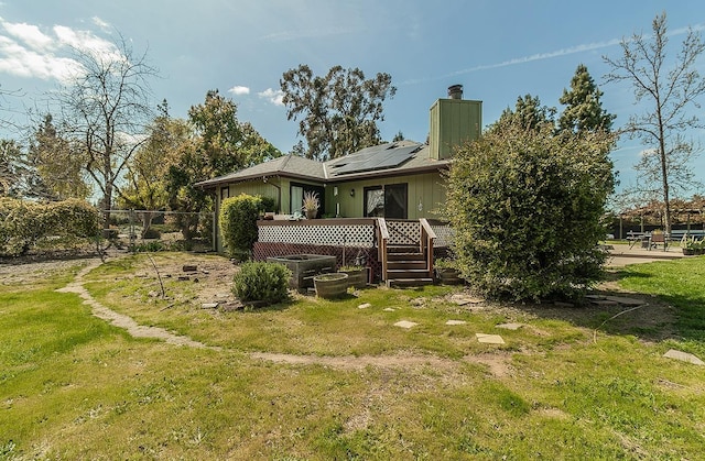 41371 Butte Way, Madera, CA 93636 - back of property with a chimney, roof mounted solar panels, and a wooden deck