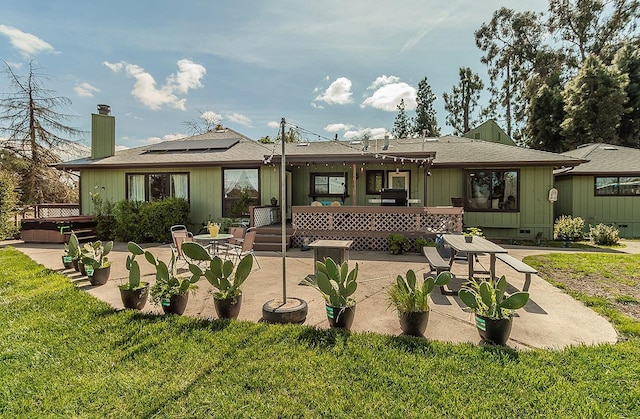41371 Butte Way, Madera, CA 93636 - rear view of house with a patio area, a chimney, a hot tub, solar panels, and a wooden deck