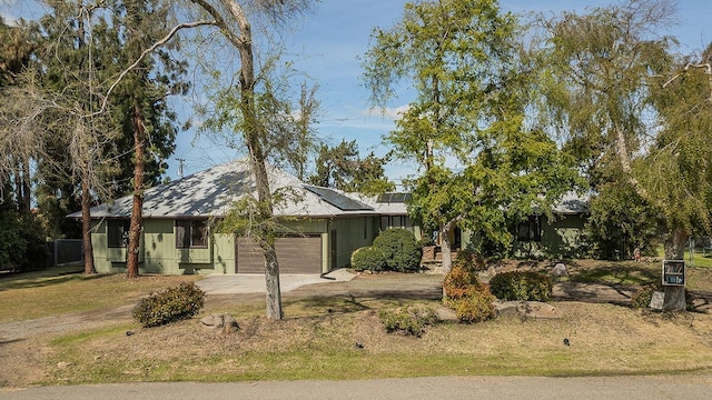 41371 Butte Way, Madera, CA 93636 - view of front of house featuring an attached garage, solar panels, and driveway