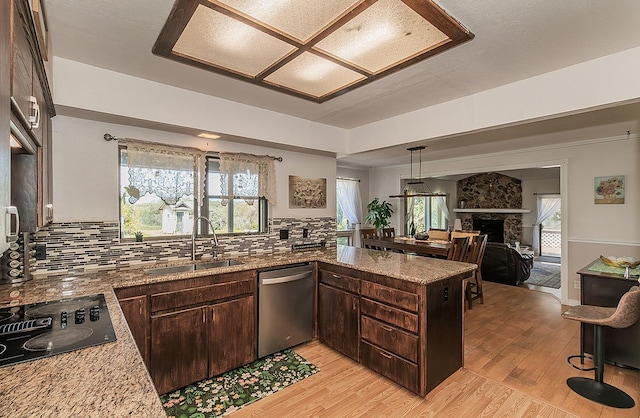 41371 Butte Way, Madera, CA 93636 - kitchen with stainless steel dishwasher, black electric cooktop, dark brown cabinetry, light wood finished floors, and tasteful backsplash