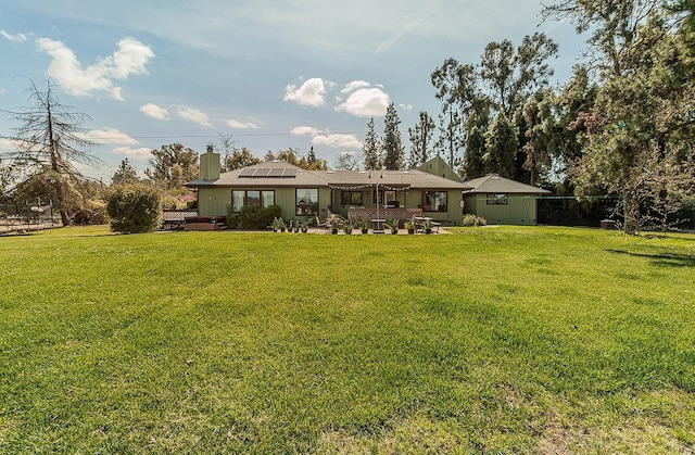 41371 Butte Way, Madera, CA 93636 - rear view of house featuring a chimney, solar panels, a lawn, and a patio
