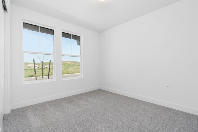 carpeted spare room with baseboards