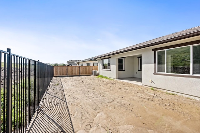 view of yard featuring a fenced backyard, central air condition unit, and a patio