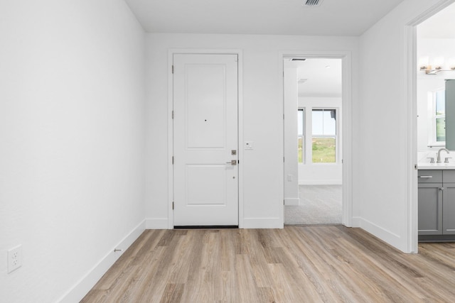 foyer featuring visible vents, light wood-style flooring, and baseboards