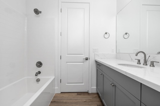 bathroom with vanity, wood finished floors, and bathing tub / shower combination