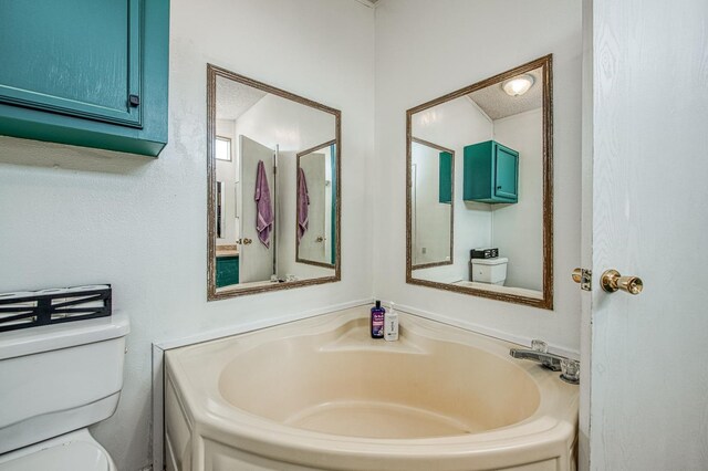 full bath featuring a garden tub and toilet