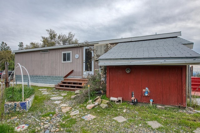 rear view of house with an outbuilding and a shed