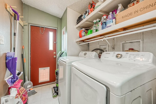 clothes washing area featuring a textured ceiling, laundry area, and washing machine and clothes dryer