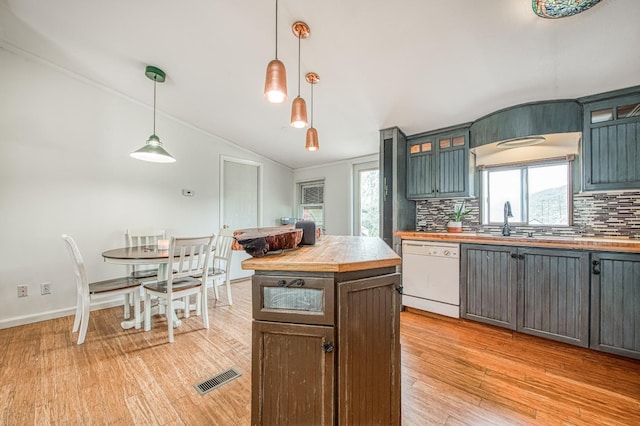 kitchen with visible vents, butcher block countertops, light wood-style floors, white dishwasher, and vaulted ceiling