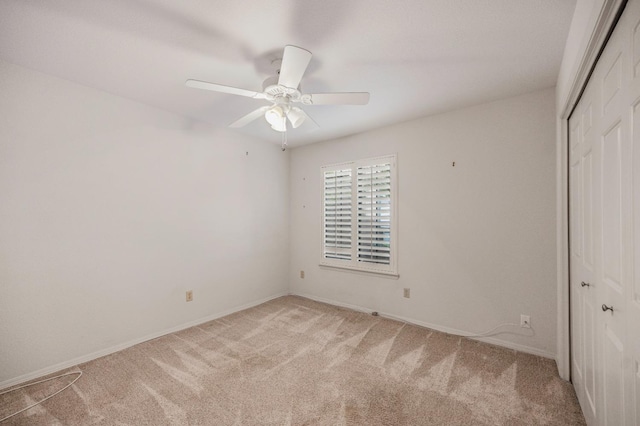 unfurnished bedroom featuring carpet flooring, a closet, baseboards, and a ceiling fan
