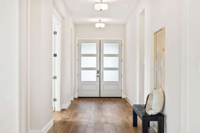doorway to outside with wood finished floors and baseboards