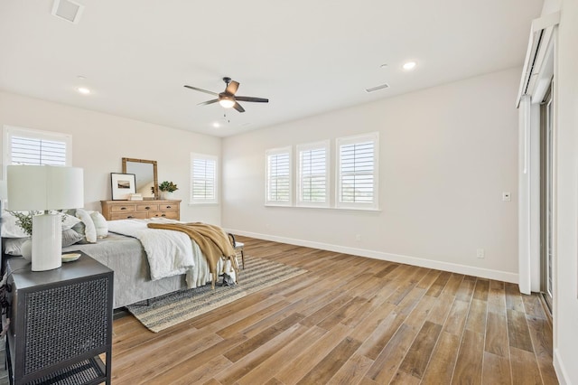 bedroom featuring visible vents, baseboards, and wood finished floors