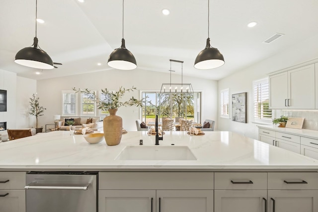 kitchen featuring visible vents, lofted ceiling, a kitchen island with sink, stainless steel dishwasher, and open floor plan