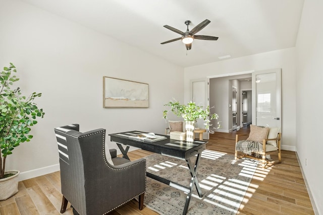 office area with baseboards, ceiling fan, and wood finished floors