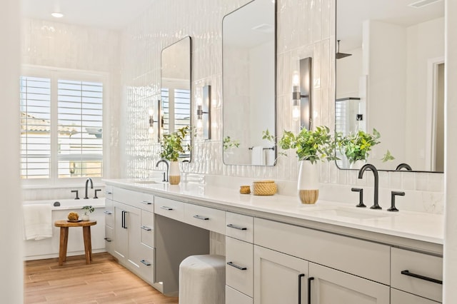 full bathroom with wood finished floors, a wealth of natural light, and a sink