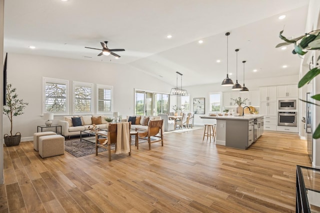 living area featuring recessed lighting, light wood-style flooring, high vaulted ceiling, and ceiling fan