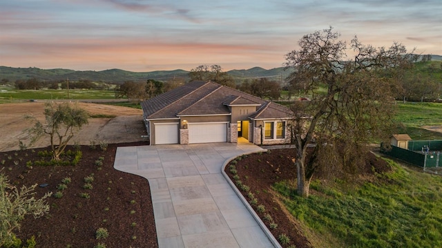 view of front of property featuring stucco siding, a mountain view, concrete driveway, a garage, and a tiled roof