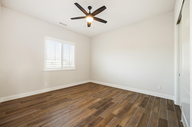 empty room with visible vents, baseboards, ceiling fan, and dark wood-style flooring