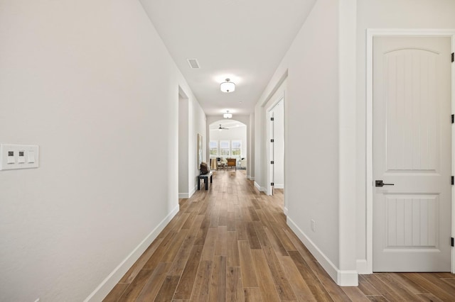hall with baseboards and wood finished floors