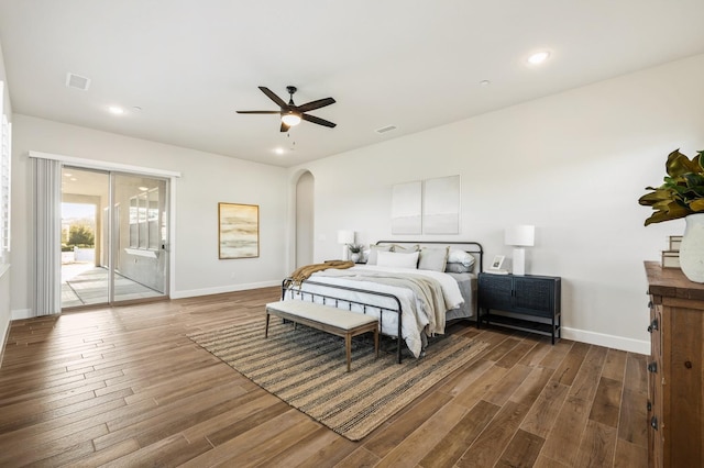 bedroom featuring access to outside, wood finished floors, visible vents, and arched walkways