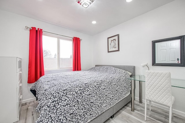 bedroom with baseboards, wood finished floors, and recessed lighting
