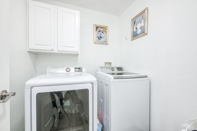 laundry area featuring washing machine and dryer and cabinet space